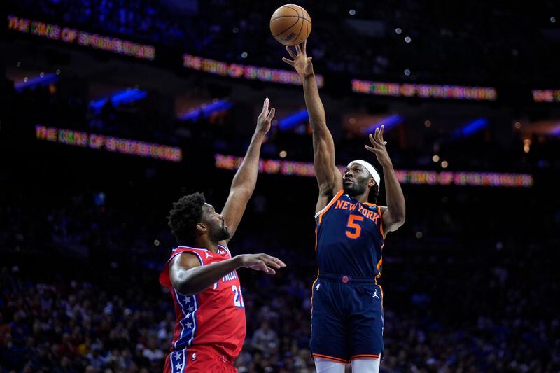 New York Knicks' Precious Achiuwa, right, goes up for a shot against Philadelphia 76ers' Joel Embiid during the first half of Game 4 in an NBA basketball first-round playoff series, Sunday, April 28, 2024, in Philadelphia. (AP Photo/Matt Slocum)