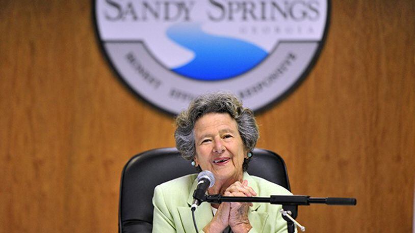 The late Sandy Springs Mayor Eva Galambos led the ceremonial “first bite” with a grapple craw in 2013 to begin the City Springs downtown redevelopment. Soil collected from around the community will be used for landscaping along a City Springs street named in her honor, Galambos Way. AJC FILE