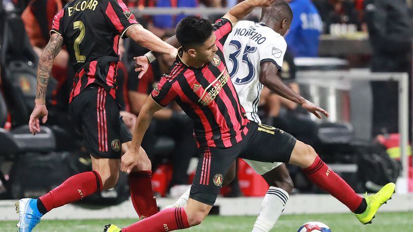 October 24, 2019 Atlanta: Atlanta United players Franco Escobar (left) and Pity Martinez drive around Philadelphia defender Jamiro Monteiro in the Eastern Conference semifinals of the MLS playoffs on Thursday, October 24, 2019, in Atlanta.   Curtis Compton/ccompton@ajc.com