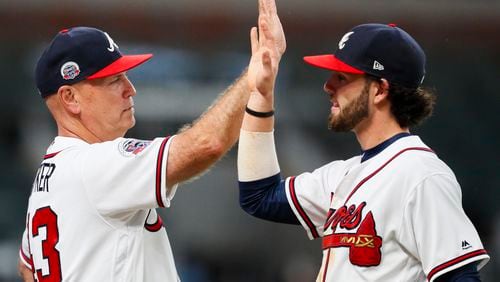 Atlanta Braves manager Brian Snitker (43) celebrates the victory with shortstop Dansby Swanson (7) after the team's baseball game against the Philadelphia Phillies, Wednesday, June 7, 2017, in Atlanta. The Braves won 14-1. (AP Photo/Todd Kirkland)