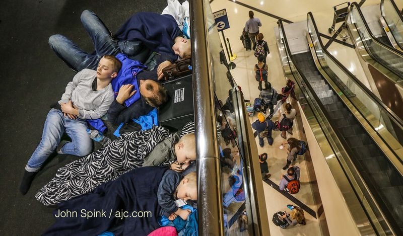 The Ravnevand family spent the night at Hartsfield-Jackson International Airport en route to Orlando. JOHN SPINK / JSPINK@AJC.COM
