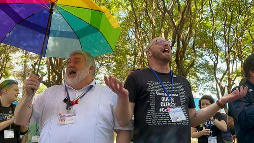 The Rev. David Meredith, left, and the Rev. Austin Adkinson sing during a gathering of LGBTQ people and allies outside the Charlotte Convention Center, in Charlotte, N.C., Thursday, May 2, 2024. They were celebrating after the General Conference of the United Methodist Church voted to remove the denomination's 52-year-old social teaching that deemed homosexuality "incompatible with Christian teaching." (AP Photo/Peter Smith)