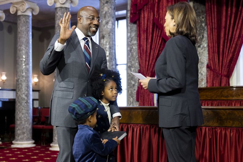 U.S. Sen. Raphael Warnock (D-GA) holds up in his hand during a ceremonial swearing in with Vice President Kamala Harris at the Capitol in Washington, DC on Jan. 3, 2022. (Nathan Posner for the Atlanta Journal-Constitution)