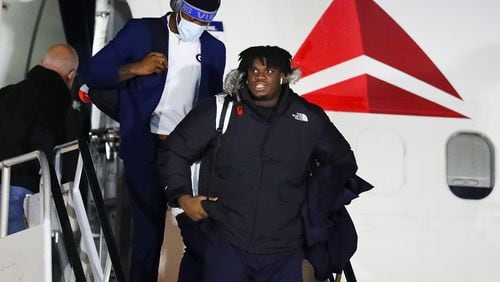Georgia defensive tackle Jordan Davis leaves the plane in the frigid cold during the College Football Playoff National Championship team arrivals at Indianapolis Airport on Friday, Jan. 7, 2022, in Indianapolis.   “Curtis Compton / Curtis.Compton@ajc.com”`