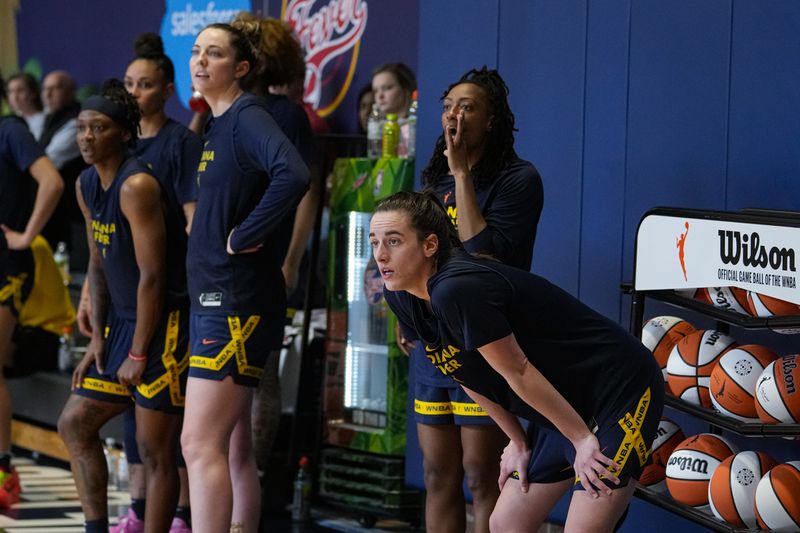 Indiana Fever guard Caitlin Clark, front right, watches from the sideline with her teammates as the WNBA basketball team practices in Indianapolis, Sunday, April 28, 2024. (AP Photo/Michael Conroy)