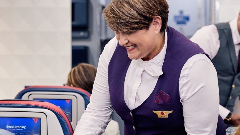A Delta flight attendant serves a customer. Delta Air Lines CEO Ed Bastian announced that it will add a sign language pin as an option for employee uniforms in the fall.