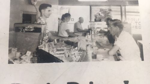 Annette Johnson is in the middle in this photo taken in Roy’s Drive-In, and her husband Roy is the dark-haired man behind the counter in the foreground.