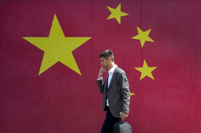 A man walks in front of a Chinese national flag in Belgrade, Serbia, Tuesday, May 7, 2024. Chinese leader Xi Jinping's visit to European ally Serbia on Tuesday falls on a symbolic date: the 25th anniversary of the bombing of the Chinese Embassy in Belgrade during NATO's air war over Kosovo. (AP Photo/Darko Vojinovic)