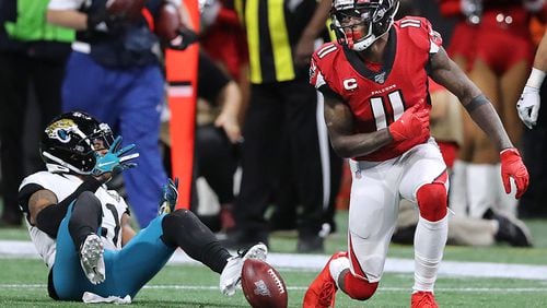 Falcons wide receiver Julio Jones spins the ball on the turf after catching a pass past Jacksonville Jaguars cornerback A.J. Bouye during the second half Sunday, Dec. 22, 2019, at Mercedes-Benz Stadium in Atlanta.