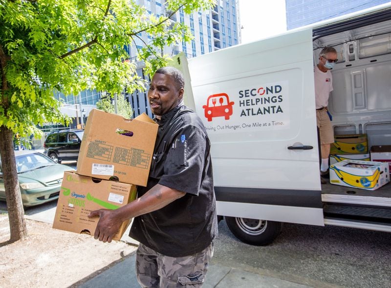 Chef Mark Crockett at the Atlanta Mission carries in donations from Trader Joe’s and Sprouts brought by Ned Cone volunteer with Second Helping Atlanta on Tuesday, June 2, 2020. (Jenni Girtman for The Atlanta Journal-Constitution)