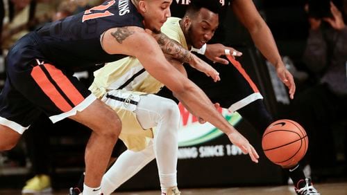 Virginia forward Isaiah Wilkins (in blue) and Georgia Tech guard Josh Okogie battle for a loose ball in the first half. (AP Photo/John Bazemore)