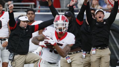 There is no shortage of joy on the Georgia sidelines as Lawrence Cager heads for the endzone against Florida Saturday. (Bob Andres / robert.andres@ajc.com)