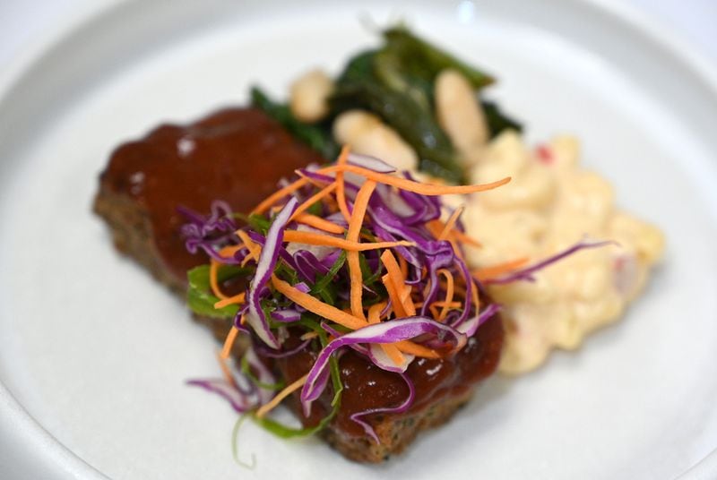 BBQ Meatloaf, pimento macaroni and cheese, beans and greens, Coca-Cola BBQ glaze, fresh slaw. Chef Molly Brandt prepared a tasting of proposed In-flight dishes at Gate Gourmet, Thursday, May 2, 2024, in Atlanta.  (Hyosub Shin / AJC)
