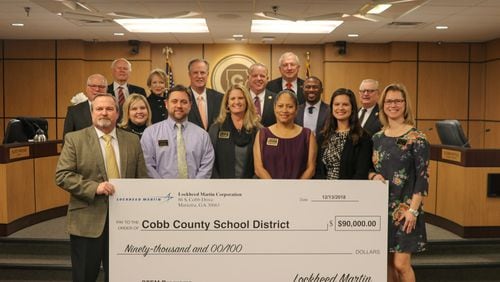 Lockheed Martin Corp. officials presented a $90,000 check for use in science, technology, engineering and math education to the Cobb County Board of Education and Cobb County School District Superintendent Chris Ragsdale during their Dec. 13 meeting. (Courtesy of the Cobb County School District)
