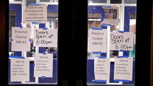 Directional signs are posted on doors at a caucus at Roosevelt Hight School, Monday, Feb. 3, 2020, in Des Moines, Iowa. (AP Photo/Andrew Harnik)