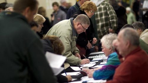 Voters sign in on caucus night at an Iowa church. AP photo.