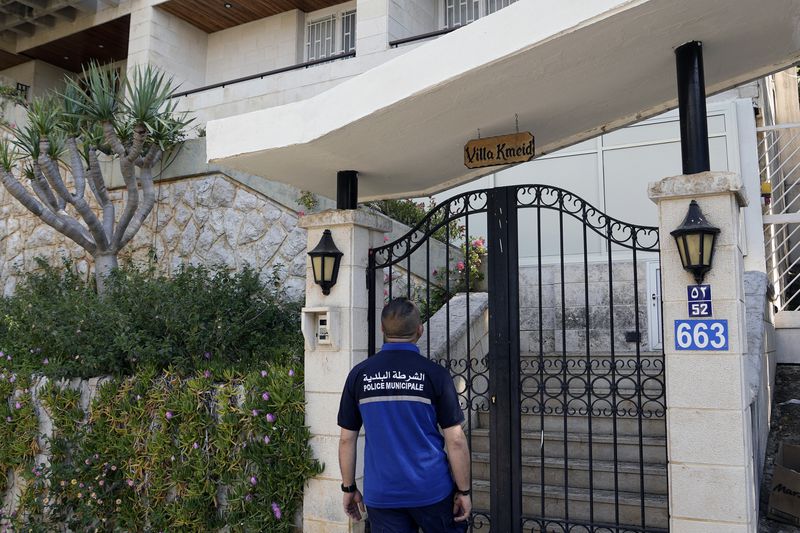 A municipal police officer stands outside a villa where the Lebanese money changer Mohammad Srour, 57, was found tortured and killed in Monte Verdi neighborhood of Beit Meri, Lebanon, Tuesday, April 16, 2024. The mysterious abduction and murder of a United States-sanctioned Lebanese money changer in a three-story villa on the edge of a quiet mountain resort town overlooking Beirut was most likely the work of Israeli operatives, Lebanon's interior minister said Wednesday. (AP Photo/Hassan Ammar)