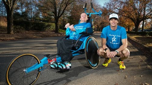 Brothers Brent, right, and Kyle Pease are shown with their race chair at the Kyle Pease Foundation Tuesday, November 28, 2017, in Roswell, Ga. Kyle, who was born with cerebral palsy spastic quadriplegia that affects all four limbs, is unable to walk. But with the help of his older brother Brent, Kyle is a two-time Ironman. The Pease brothers started the Kyle Pease Foundation. Their mission is to help other disabled individuals experience the joy of sport by providing medical and adaptive sports equipment, mobility devises and medical care. PHOTO / JASON GETZ - AJC file