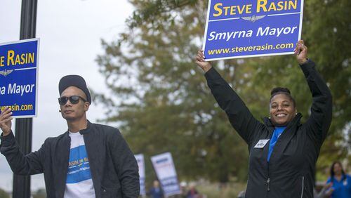 Shayna Rasin (right) and her husband Ramsis Saniatan (left) campaign for Shayna’s father, Smyrna mayoral candidate Steve Rasin, near the Smyrna Comminy Center polling place during Election Day in Smyrna, Tuesday, November 5, 2019. (Alyssa Pointer/Atlanta Journal Constitution)