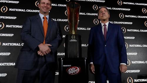 Clemson coach Dabo Swinney and Alabama coach Nick Saban pose with the championship trophy during a news conference for the College Football Playoff on Sunday, Jan. 8, 2017, in Tampa, Fla. (AP Photo/David J. Phillip)