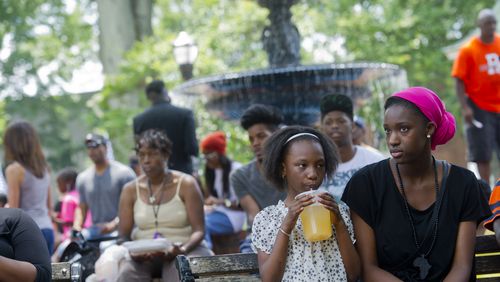Isha Faye (right) and Oumie Faye sit on a bench as they watch the performances during the Cobb NAACP Juneteenth Celebration in Marietta Square. JONATHAN PHILLIPS / SPECIAL