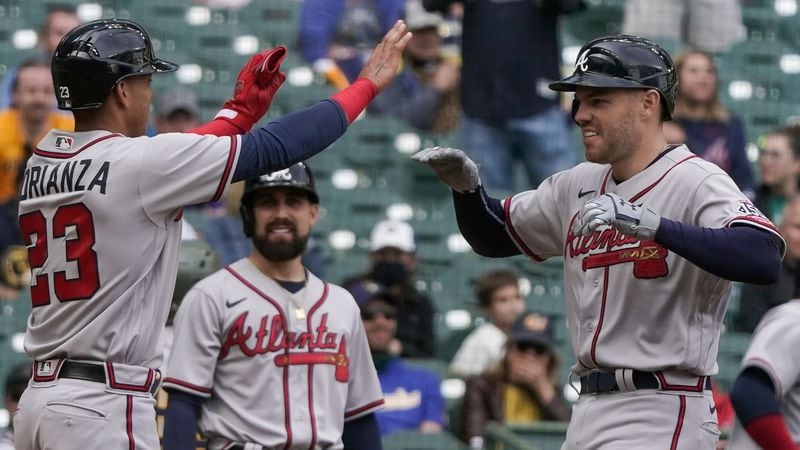 Braves first baseman Freddie Freeman is congratulated by Ehire Adrianza (left) after hitting a grand slam during the seventh inning Sunday, May 16, 2021, against the Brewers in Milwaukee. (Morry Gash/AP)