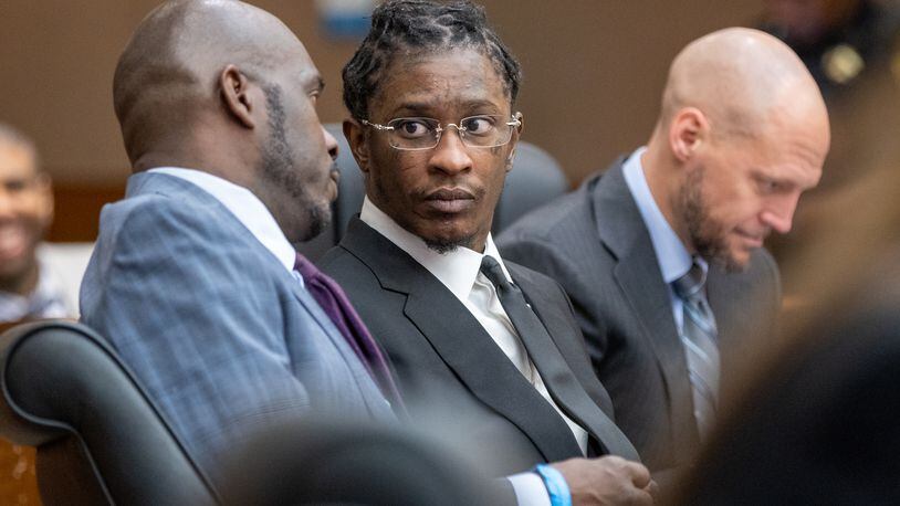 Young Thug (center) speaks with attorney Keith Adams during a pre-trial hearing. The Atlanta rapper, whose real name is Jeffery Williams, was one of 28 people charged in a sweeping Fulton County gang indictment this year. (Arvin Temkar / arvin.temkar@ajc.com)