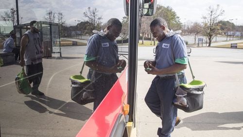 Simon Tshimanga of Duluth jokes with a Gwinnett County transit bus driver while boarding a bus at the Gwinnett Transit Center in Duluth, Friday, February 23, 2018. Simon, a second shift custodian with ABM, uses the transit system to get to work. ALYSSA POINTER/ALYSSA.POINTER@AJC.COM