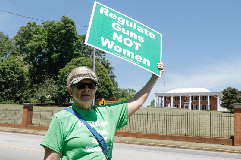Carol Baird holds up a sign that reads Regulate Guns Not Women across from the Governor’s mansion on Thursday, May 4, 2023, the day after a deadly shooting at a Northside Hospital medical building in Midtown Atlanta.  “There’s not a better day to go to the Governer’s mansion after what happened yesterday.” (Natrice Miller/natrice.miller@ajc.com)