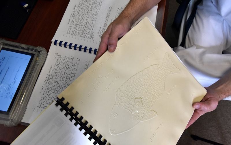 October 26, 2017 Macon - Elmer Hamilton, an inmate and certified braille transcriber, shows how he transcribed fish into braille at Braille Program at Central State Prison in Macon on Thursday, October 26, 2017. Braille program turns inmates into transcribers and transforms textbooks into books for the visually impaired read. HYOSUB SHIN / HSHIN@AJC.COM