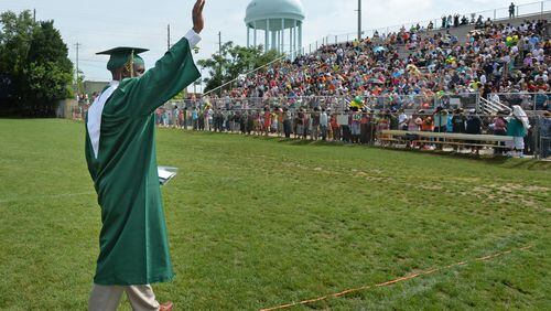 Hezekiah Jordan, son of fallen Griffin police officer Kevin Jordan, waves after he received his diploma during the Griffin High School 2014 Graduation Ceremony. I hope someone cheered without being arrested. (HYOSUB SHIN / HSHIN@AJC.COM)