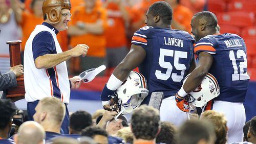 090515 ATLANTA: Auburn head coach Gus Malzahn (from left) shares a laugh with Carl Lawson and Jonathan Wallace as he puts on the "leather helmet" trophy winning the Chick-fil-A Kickoff Game 31-24 over Louisville on Saturday, Sept. 5, 2015, in Atlanta. Curtis Compton / ccompton@ajc.com