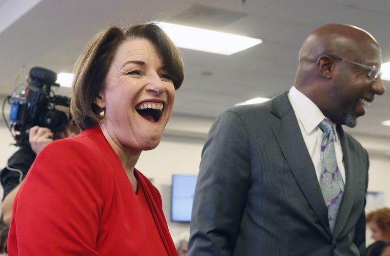 November 21, 2019 - Atlanta - Amy Klobuchar shares a laugh with Ebenezer Baptist Church pastor Rev. Raphael G. Warnock.  Democratic presidential candidates including Cory Booker, Amy Klobuchar, Andrew Yang and Pete Buttigieg, along with Stacey Abrahms,  were calling and texting voters Thursday whose registrations could be canceled in Georgia at a Fair Fight phone bank at Ebenezer Baptist Church in Atlanta. The phone bank was in response to Georgia election officials' plan to cancel more than 313,000 voter registrations next month.   Bob Andres / robert.andres@ajc.com