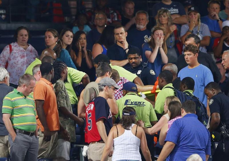 Rescue workers carry Greg Murrey, of Roswell, from the stands at Turner Field during a 2015 game between Atlanta Braves and New York Yankees Saturday. Murrey fell the upper desk onto concrete below and was pronounced dead on arrival at Grady Memorial Hospital. 