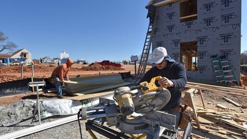 Construction hiring was strong last month, according to the Labor Department. Here, construction crews work recently on Pinewood Forest, a mixed-use development, in Fayetteville. HYOSUB SHIN / HSHIN@AJC.COM