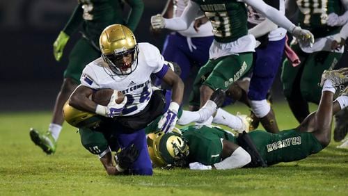East Coweta running back DJ Reid (24) is brought down by Grayson’s defense in the first half of play during during a GHSA first round state playoff game Friday, Nov. 12, 2021 at Grayson High School. (Daniel Varnado/ For the Atlanta Journal-Constitution)