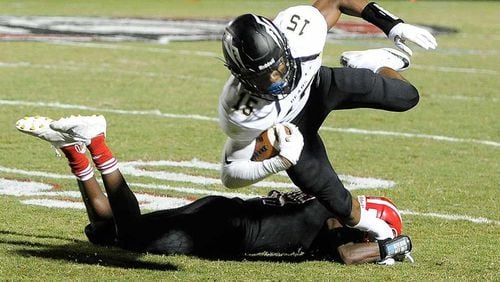 Mountain View WR Malachi Carter (15) gets tripped up by North Gwinnett DE Dixon Yellott during the first half of Friday's game. (John Amis/Special)