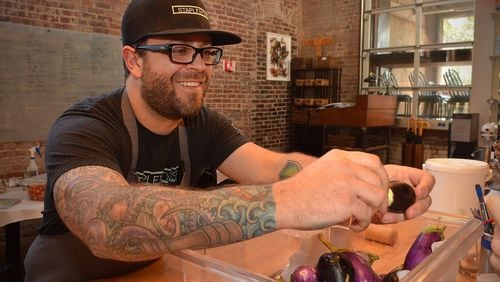 Staplehouse chef Ryan Smith carefully goes through a container of organic eggplant prior to preparation. (Chris Hunt / special)