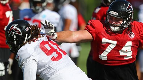 Falcons defensive end Takk McKinley (left) tries to rush around tackle Ty Sambrailo on the first day in pads at training camp Wednesday, July 24, 2019, in Flowery Branch.