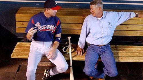 Chipper Jones and his dad, Larry, chat in the dugout before batting practice.