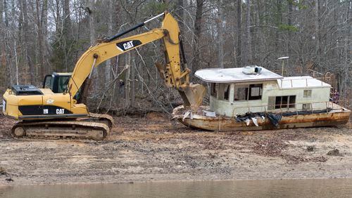 An abandoned houseboat, nicknamed the Museum Houseboat, is dragged away from Lake Lanier in Cumming, Georgia, on Monday, February 27, 2017. After being declared debris, the Lake Lanier Association was able to remove the boat, which is the third vessel removed with state allocated funds this fiscal year.