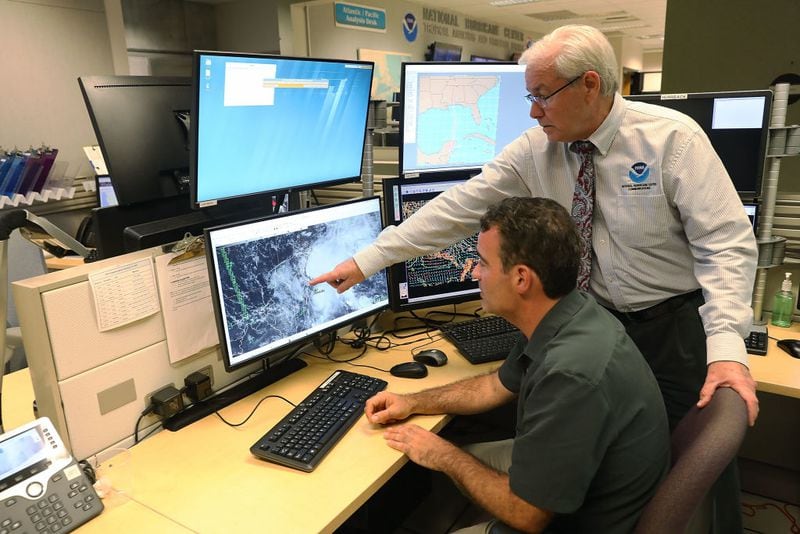 MIAMI, FL - MAY 24:  Hurricane Specialist John Cangialosi (L) and Dennis Feltgen, the Communications and Public Affairs Officer, work at the National Hurricane Center as they look at a computer screen showing the first subtropical depression of the 2018 Atlantic hurricane season on May 24, 2018 in Miami, Florida. Subtropical Storm Alberto formed Friday in the Caribbean Sea.  (Photo by Joe Raedle/Getty Images)