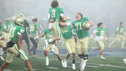 Buford's Eli Parks (3), Will Harkness (16) and Jackson Favors (71) celebrate after Langston Hughes missed a field-goal attempt as Buford won 21-20 in the Class 6A state title football game in December at Georgia State Center Parc Stadium. (JASON GETZ / FOR THE ATLANTA JOURNAL-CONSTITUTION)