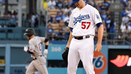 Los Angeles Dodgers pitcher Alex Wood (57) looks down as Colorado Rockies' Trevor Story rounds the bases after hitting a two-run home run during the second inning of a baseball game Saturday, Sept. 9, 2017, in Los Angeles. (AP Photo/Michael Owen Baker)