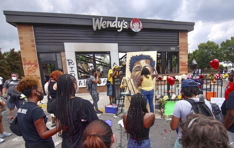 Ashley Dopson paints a picture of Rayshard Brooks on June 14, 2020, in the Wendy’s parking lot in southwest Atlanta where Brooks was killed by a police officer on June 12, 2020. (Steve Schaefer for The Atlanta Journal-Constitution)