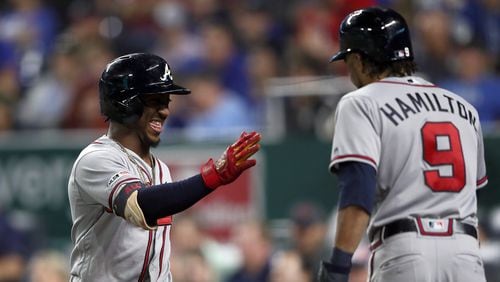 Ozzie Albies (left) of the Atlanta Braves is congratulated by Billy Hamilton after scoring during the 6th inning of the game against the Kansas City Royals at Kauffman Stadium on September 25, 2019 in Kansas City, Missouri. (Photo by Jamie Squire/Getty Images)