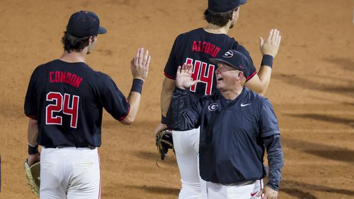 Georgia head coach Wes Johnson celebrates with Georgia third baseman Charlie Condon (24) and Georgia second baseman Slate Alford (44) after their win against Vanderbilt 10-0 in the seventh inning at Foley Field, Friday, May 3, 2024, in Athens, Ga. No. 19-ranked Georgia defeated No. 13 Vanderbilt 10-0. (Jason Getz / AJC)
