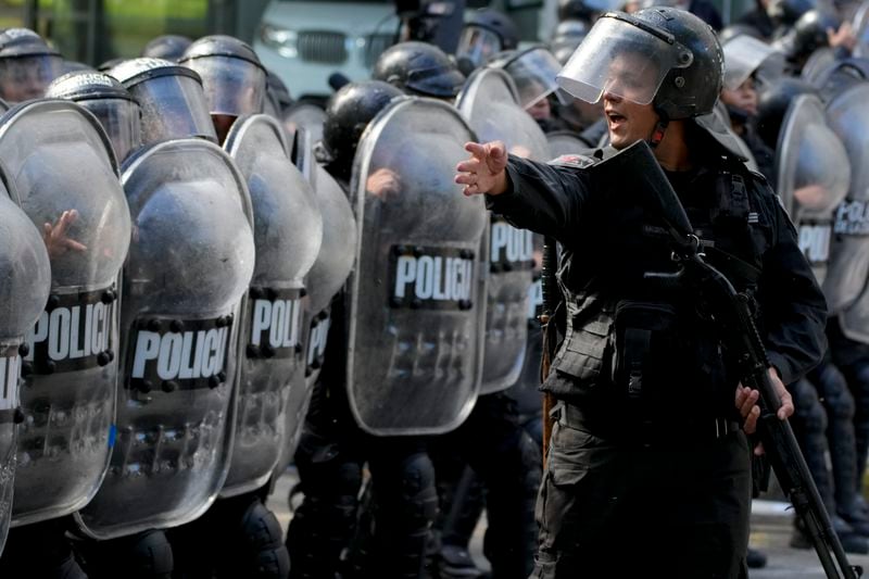 Police organize themselves as they work to disperse an anti-government protest against food scarcity at soup kitchens and against economic reforms proposed by President Javier Milei in Buenos Aires, Argentina, Wednesday, April 10, 2024. (AP Photo/Natacha Pisarenko)