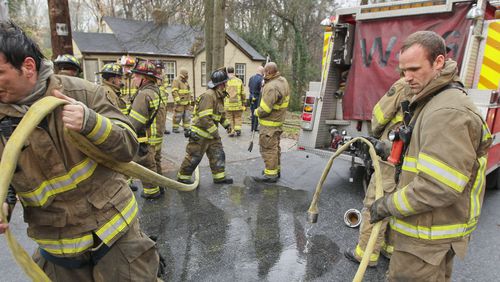 Feb. 14, 2012 Atlanta : Atlanta firefighters Frank Martinez and Chris Moss (right) of Squad 4 roll up hose after battling a blaze Tuesday. Atlanta firefighters made a quick knock down on a house fire at 1750 Madrona Street in Atlanta Tuesday, Feb. 14, 2012. Two occupants of the house were already evacuated when crews arrived on the call that came in at 10:09 AM according to battalion chief, Raymond Bearden. The bulk of the fire was in the basement where after crews checked for extensions throughout the house and made complete searches. There were no exposure problems to the adjacent neighboring homes. No one was hurt and the fire is under investigation..  John Spink, jspink@ajc.com