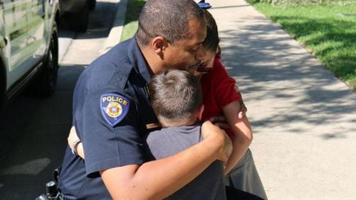 Round Rock police Chief Allen Banks hugs Ximena and her brother during a visit to their home. Ximena had given her $4 allowance to the Police Department as a kind gesture after the funeral of Round Rock police officer Charles Whites last week.
